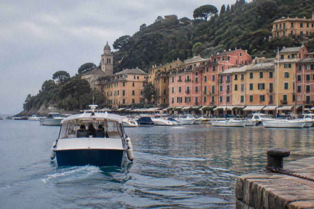 Passenger boat approaching a stone jetty on the Ligurian coast