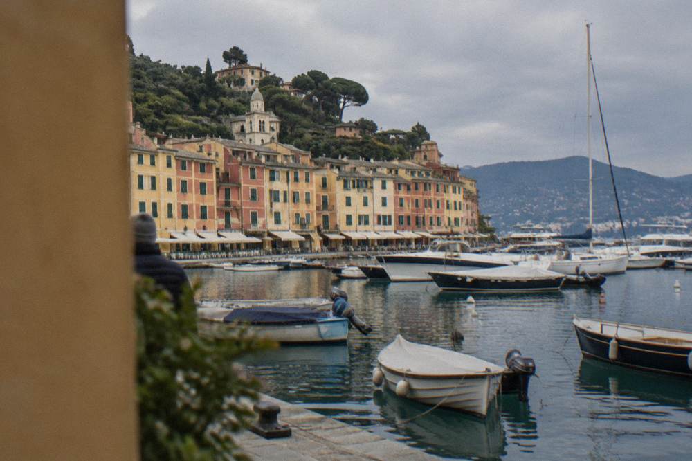 Boats moored in Rapallo harbour with the hills of the Portofino promontory in the distance