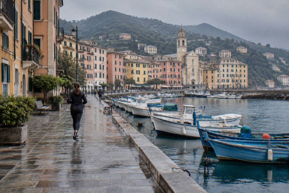 Colourful Ligurian buildings along a seafront promenade with parked fishing boats
