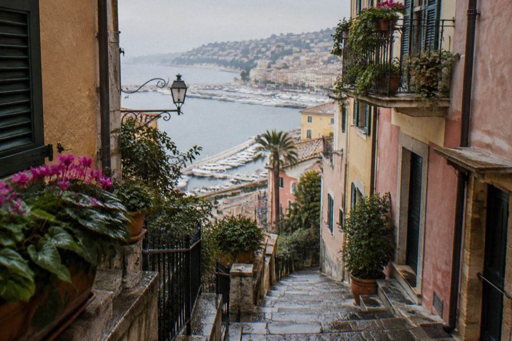 Narrow stepped lane winding between tall old houses in a hillside town