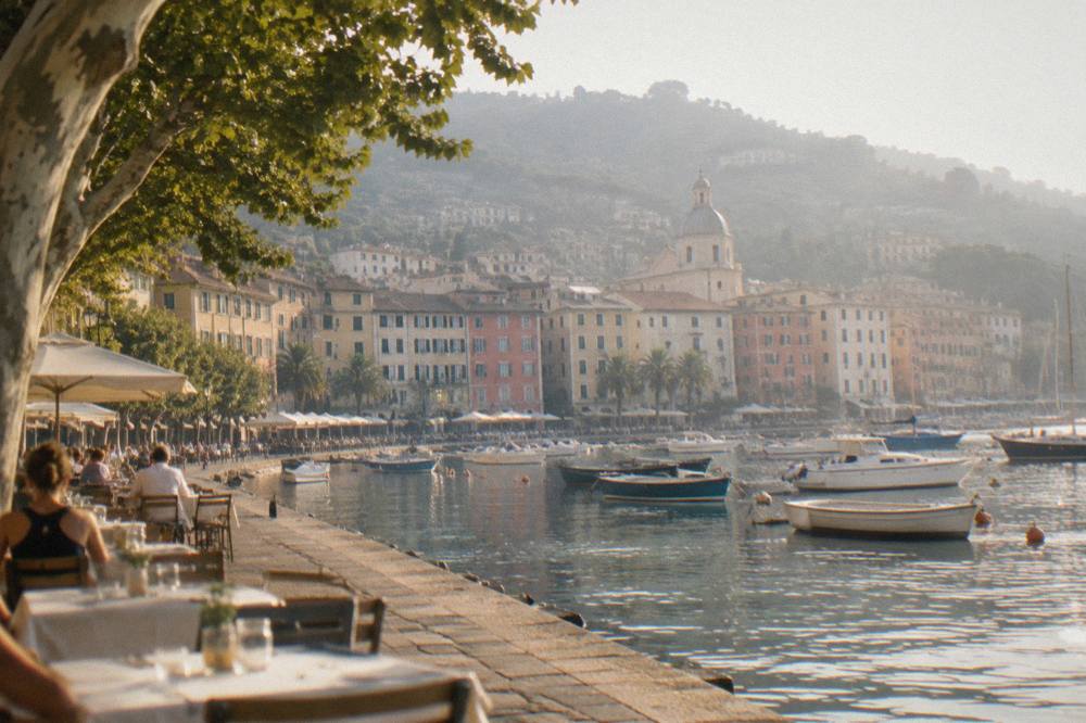 Evening light on the harbour front of Santa Margherita Ligure with tables along the water