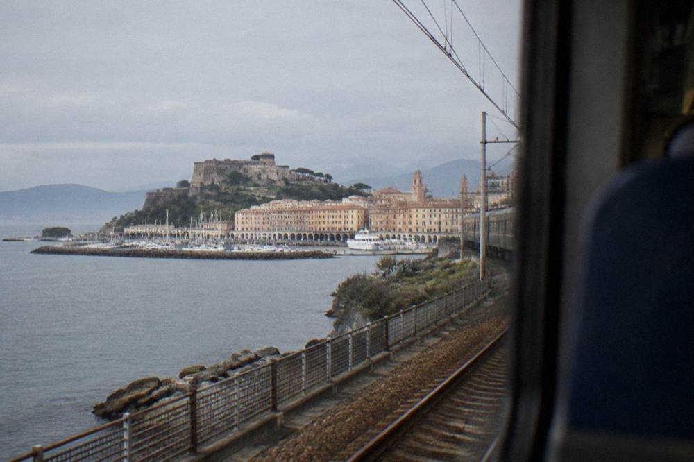 A regional train travelling along a coastline with the sea on one side