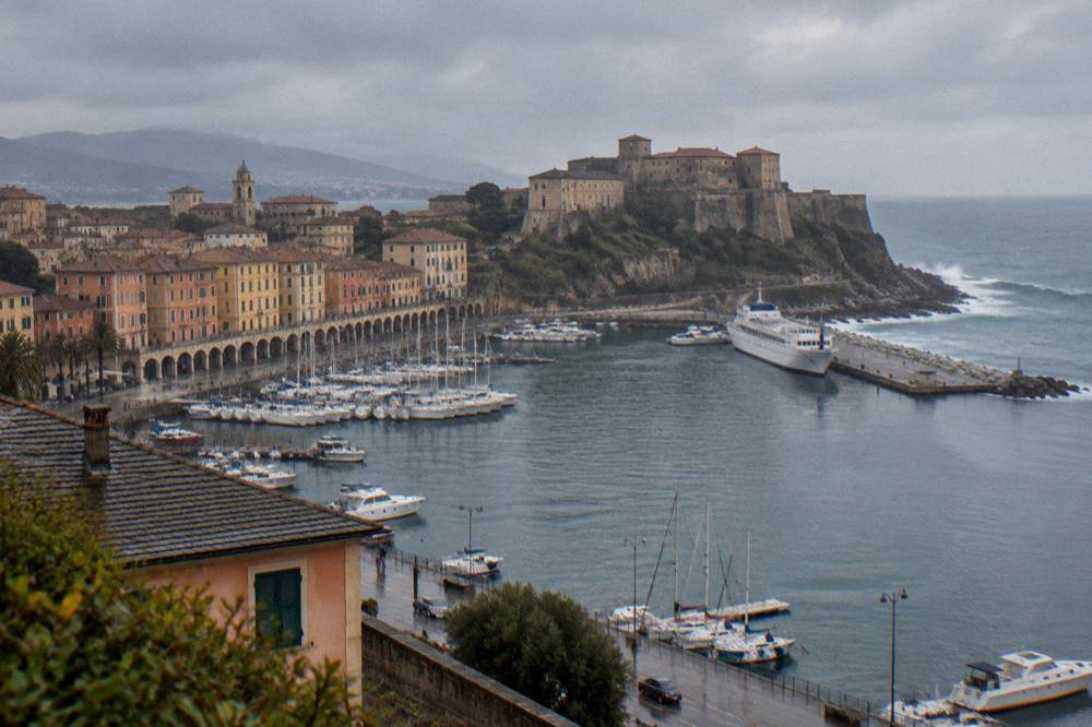 Waves breaking against rocks on the Ligurian coast under a cloudy sky