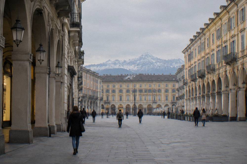 Arcaded shopping street in central Turin with pedestrians in late afternoon light