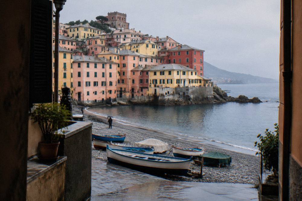 The colourful houses of Boccadasse village above a small pebble beach in Genoa