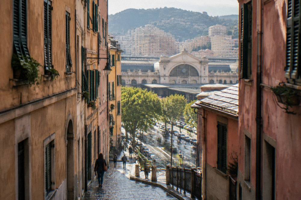 Narrow cobbled alley between tall old buildings in a Mediterranean city