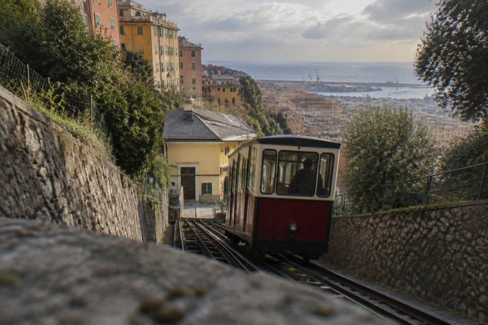 Funicular carriage climbing a hillside above city rooftops