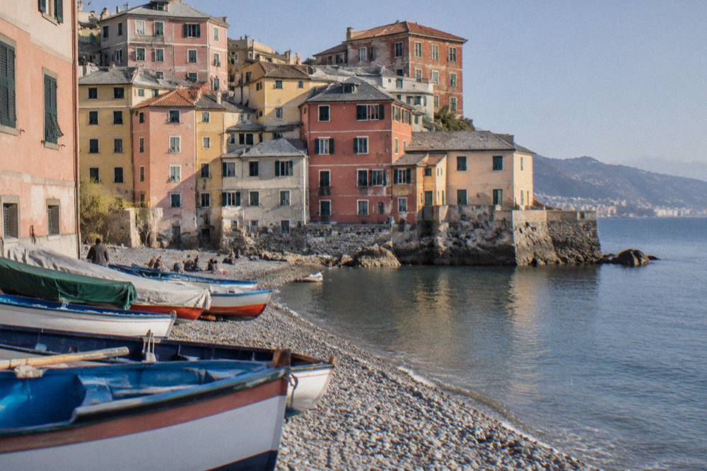Fishing boats and coloured houses along a small pebble beach in Boccadasse