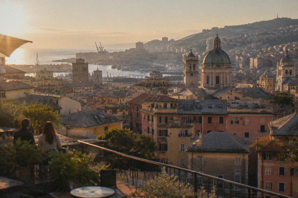 Panoramic terrace overlooking the rooftops and harbour of Genoa at golden hour