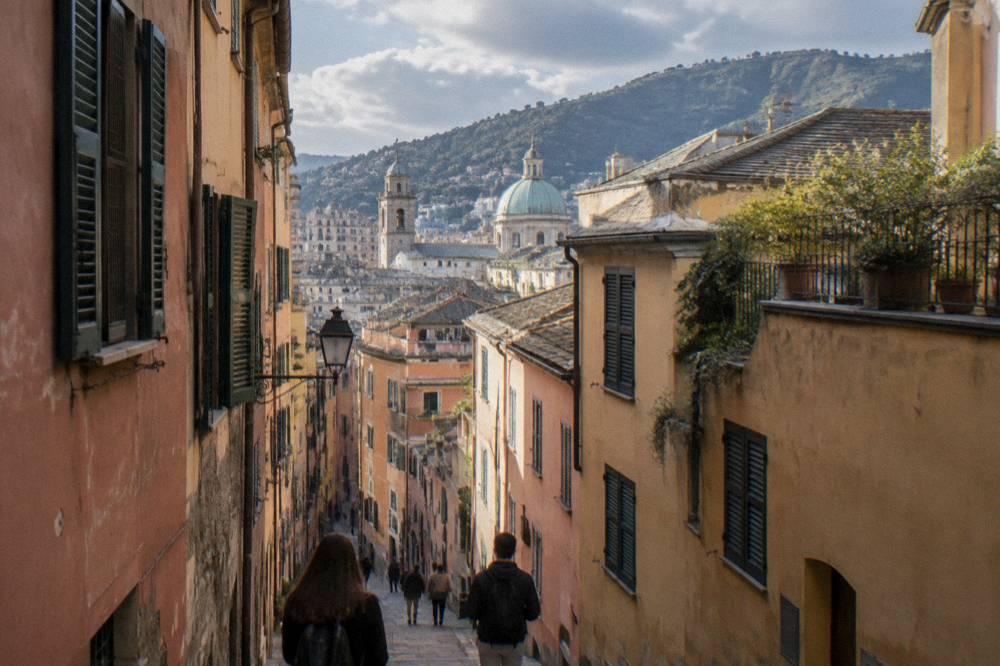Travellers walking through a narrow medieval street in Genoa's old town