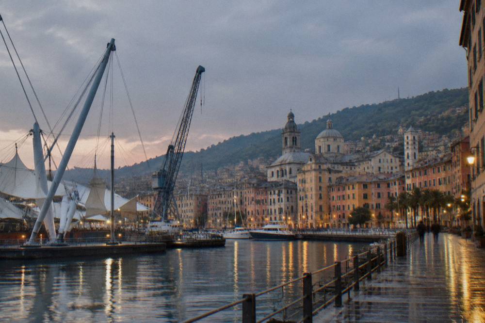 Gennaker and crane structures above the old harbour of Genoa at dusk