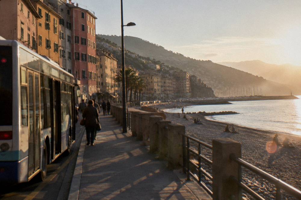 City bus stopping on a seaside street near a beach promenade