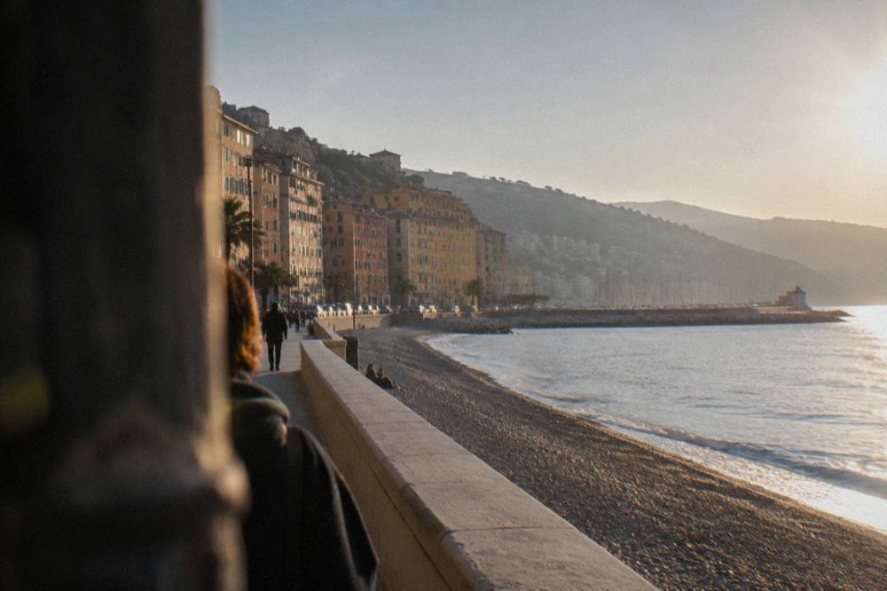 Pastel apartment buildings facing the sea along a Ligurian waterfront road