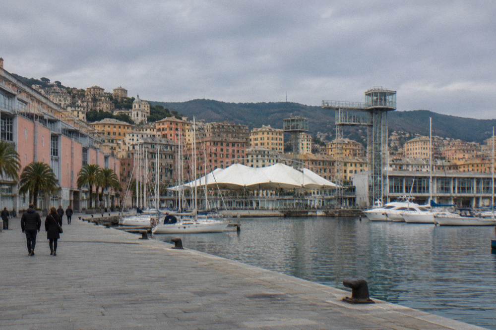 An old harbour basin with a panoramic lift structure and museum buildings along the quay