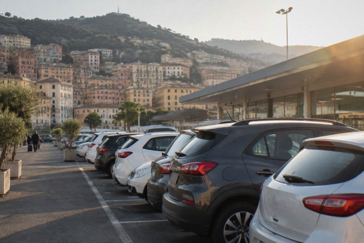 Rental cars parked in a row outside a coastal Italian airport terminal