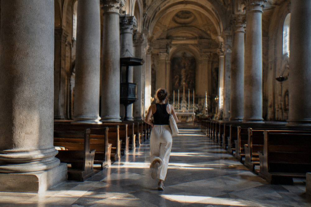 Nave of a Genoa church with stone columns and arched ceiling