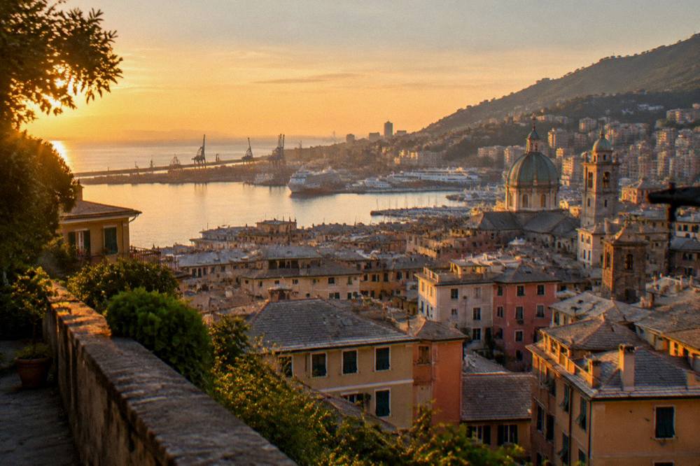 Evening light over rooftops and the harbour of Genoa from a hillside terrace