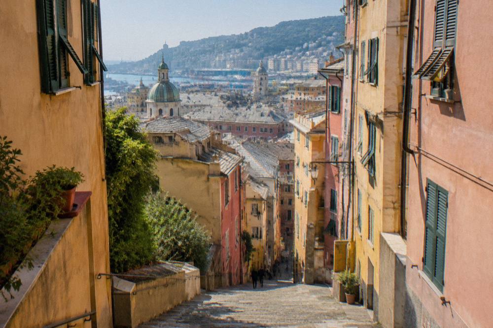 Narrow stepped alley in the old town of Genoa with tall coloured buildings