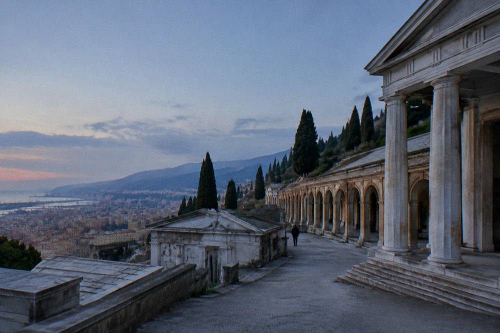 Carved marble monuments on a hillside terrace at Staglieno cemetery