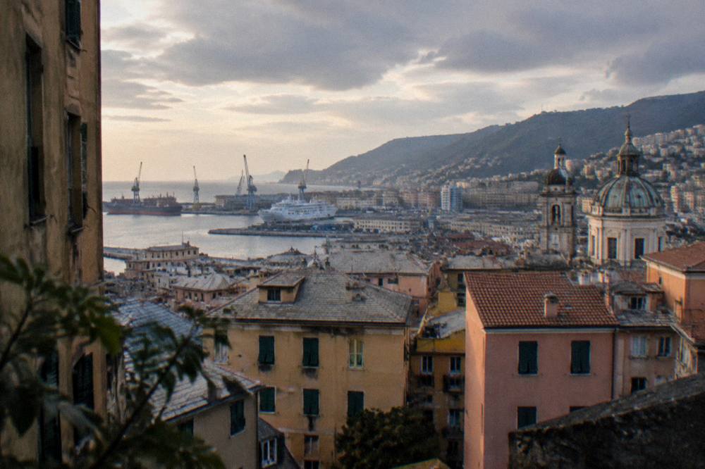 Evening light over the port of Genoa with ships and cranes along the waterfront