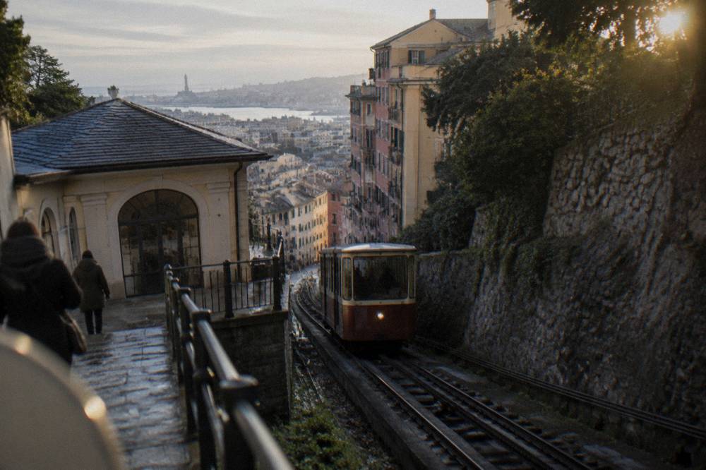 A funicular carriage climbing a steep track between buildings in Genoa