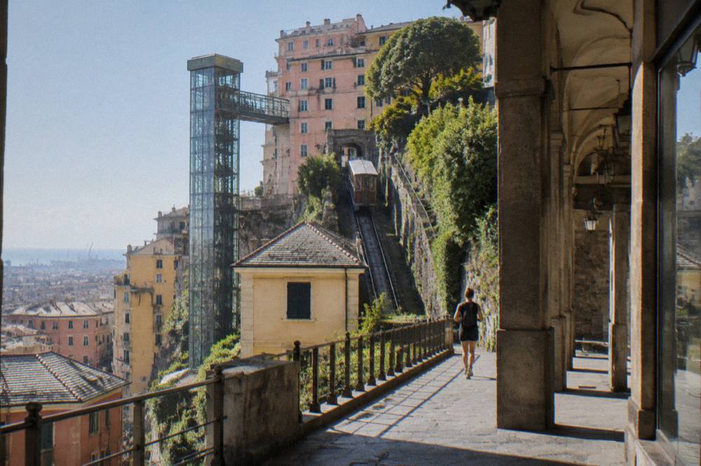The glass lift shaft of the Castelletto lift seen from a covered shopping street in Genoa