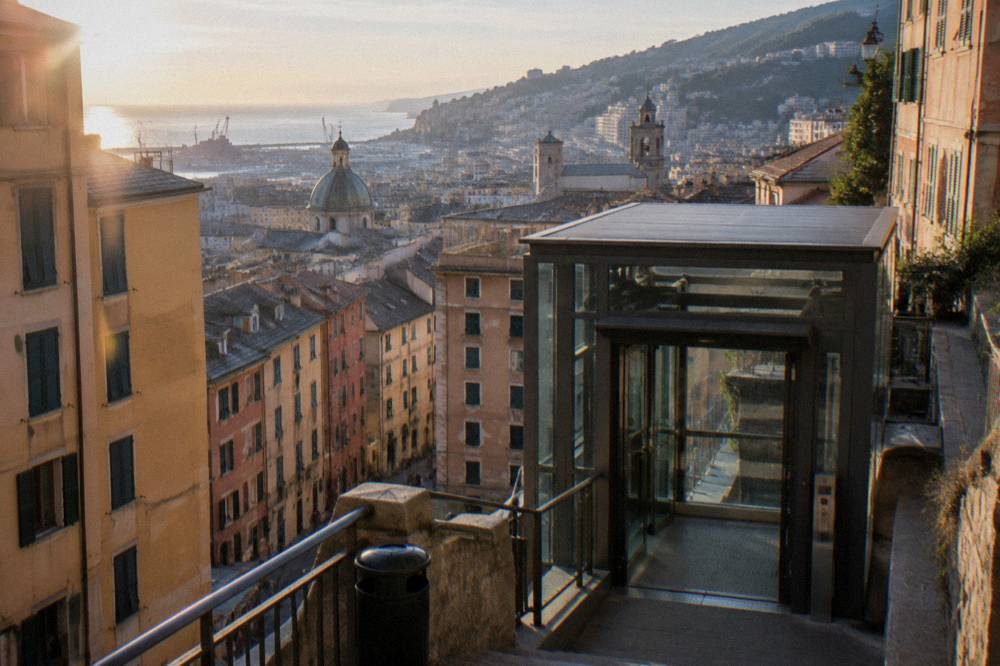 The entrance to a public elevator station in Genoa with AMT signage on a hillside street