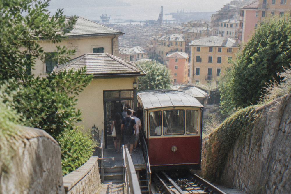 Travellers boarding a funicular car at a hillside station in Genoa