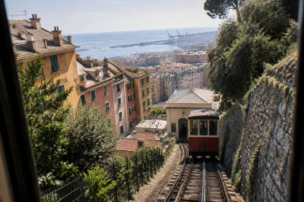 View from a funicular window of Genoa's terraced hillside houses descending toward the sea