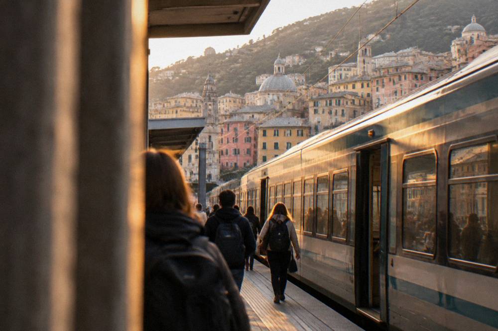 Train arriving at a Genoa station platform with passengers carrying backpacks