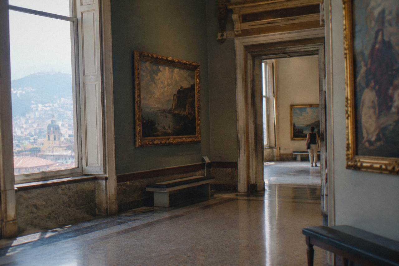 Gallery rooms inside a historic Genoa palace museum with paintings on the walls