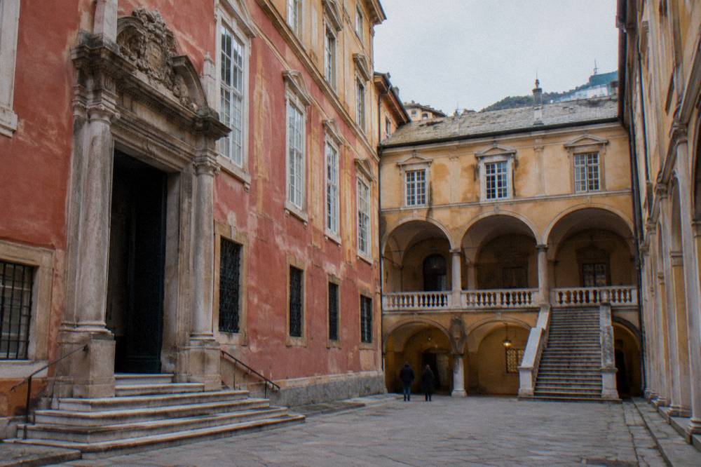 Courtyard of a grand civic palace with arched walkways and stone staircases