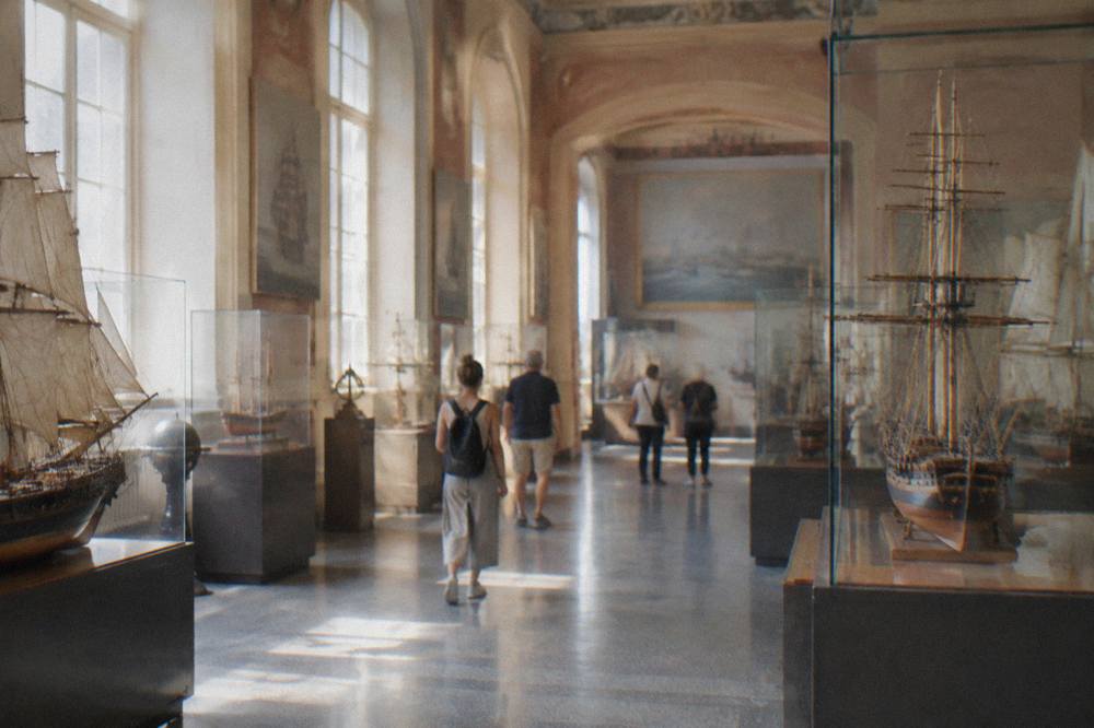 Visitors walking through a museum hall with model ships and maritime displays