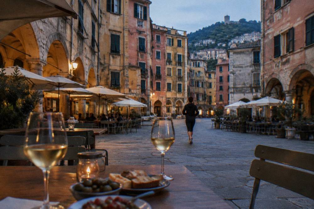 Glasses of white wine and small plates on a wooden table at dusk