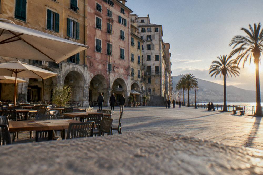 Seaside promenade at sunset with palm trees and the Ligurian Sea