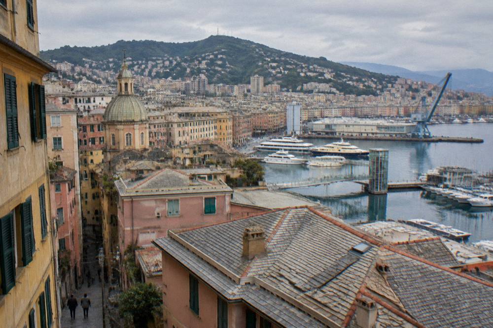 Old harbour waterfront in Genoa with a panoramic lift, crane structure and boats