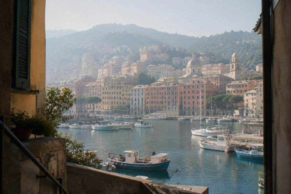 Fishing boats moored in a small Ligurian harbour with hills behind