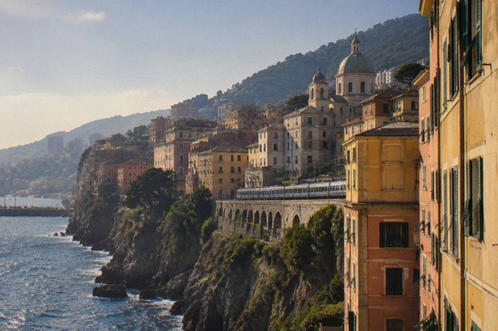 A train travelling along a cliffside railway above the sea