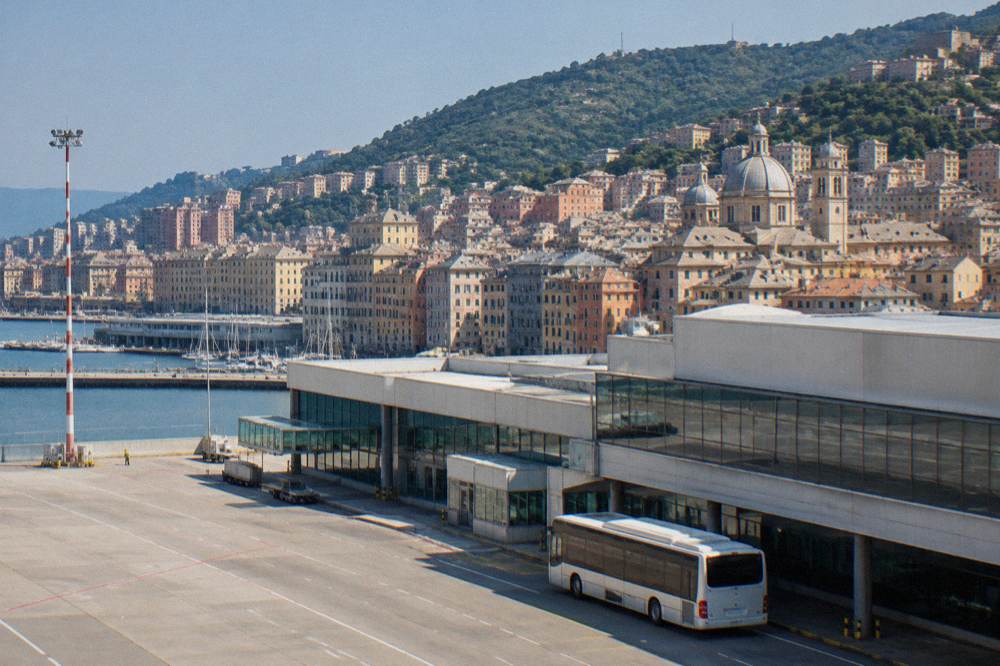 An airport shuttle bus parked outside Genoa Cristoforo Colombo airport terminal