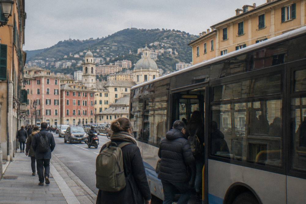 Passengers boarding a bus on a busy street in central Genoa