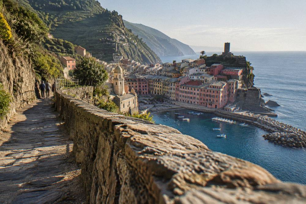 A stone footpath winding along a cliff above the sea between two villages