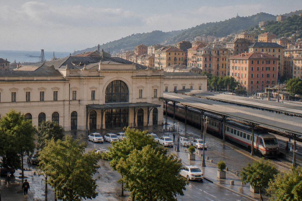A long-distance train waiting at a platform under a station roof in Italy