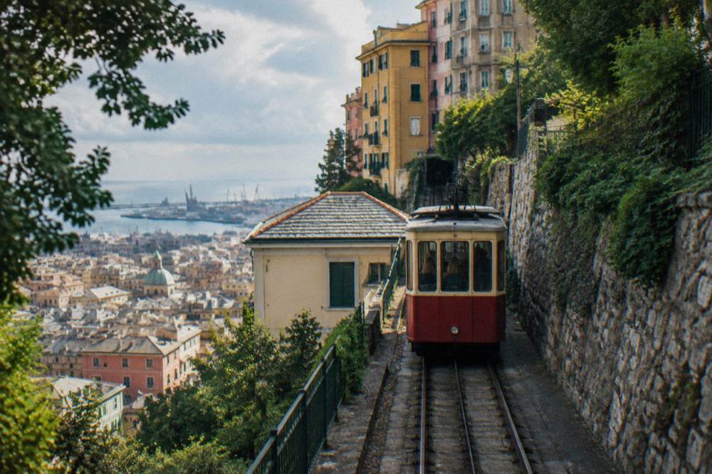 A funicular car climbing a steep hillside street above a dense city centre