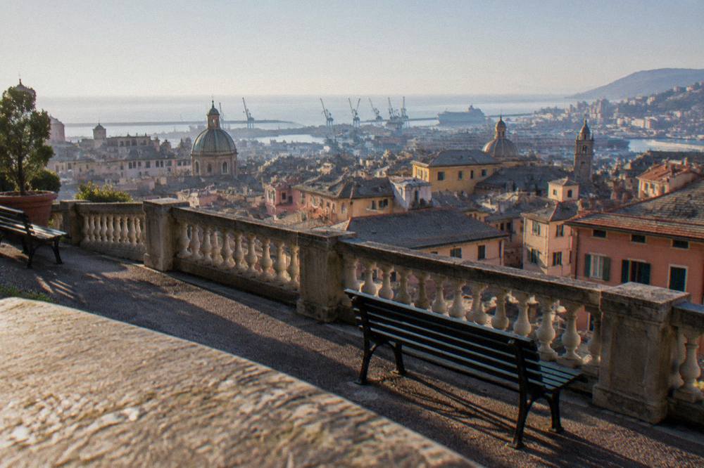 A historic palace rooftop terrace overlooking rooftops that descend to the sea