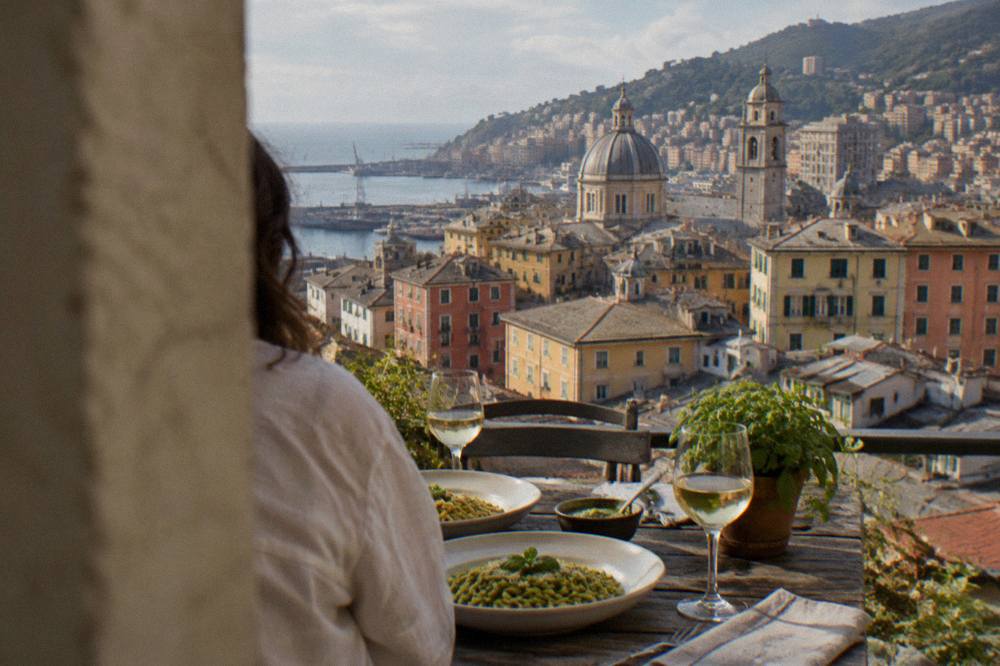 A rooftop table in Genoa with fresh pasta, basil pesto and glasses of white wine