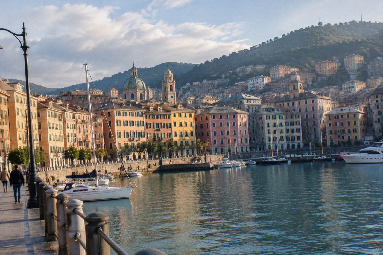 The Genoa waterfront under a mix of sun and cloud over the Ligurian Sea
