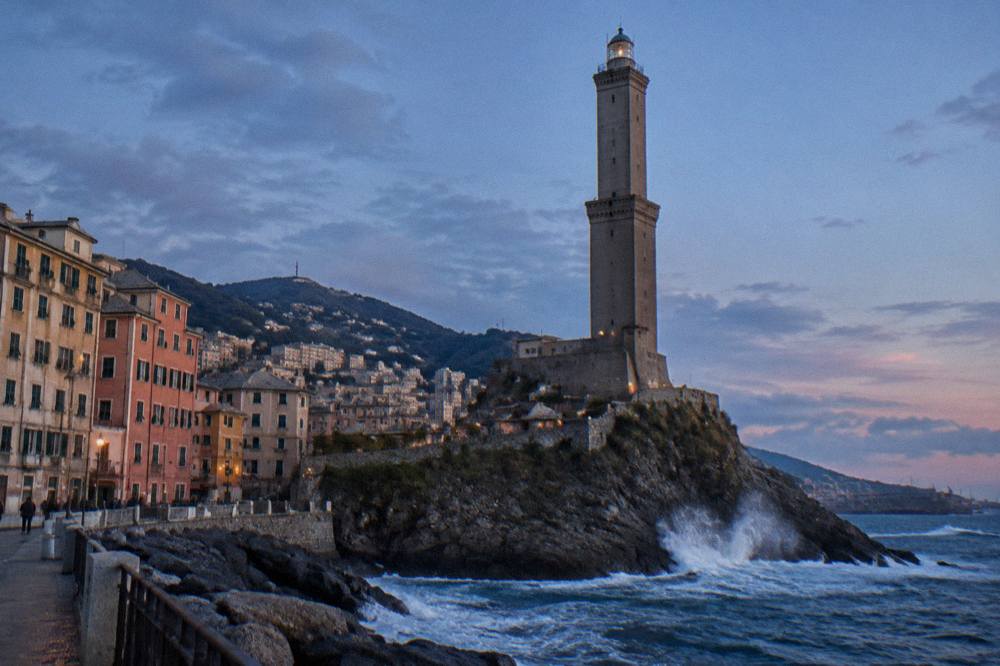 Waves breaking against the seafront at the Lanterna lighthouse in Genoa