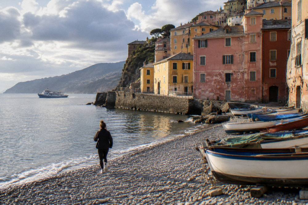 A ferry boat crossing calm water towards the cliffs of the Ligurian coast