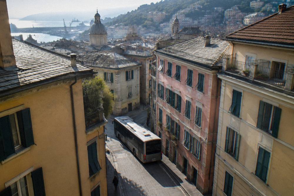 A city bus turning a narrow street in central Genoa