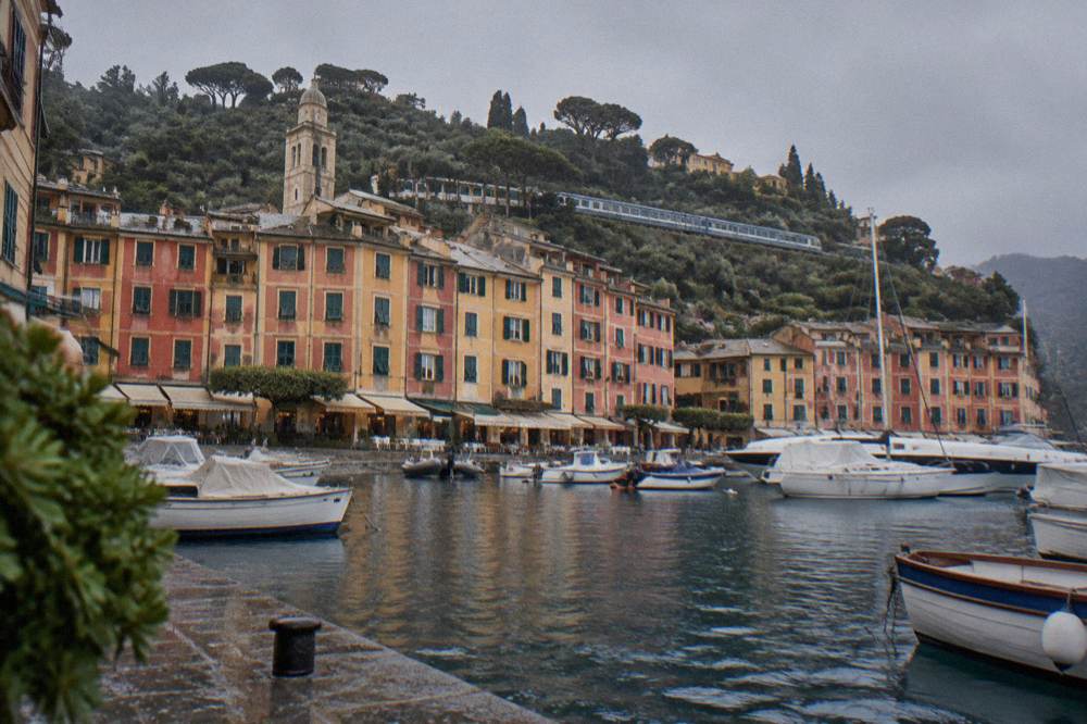 A regional train stopping at a small station above the Ligurian sea